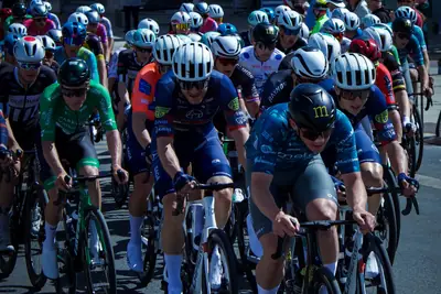 A bunch of riders on a closed street with spectators