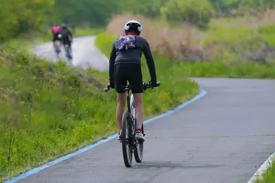 A cyclist on a winding green countryside road
